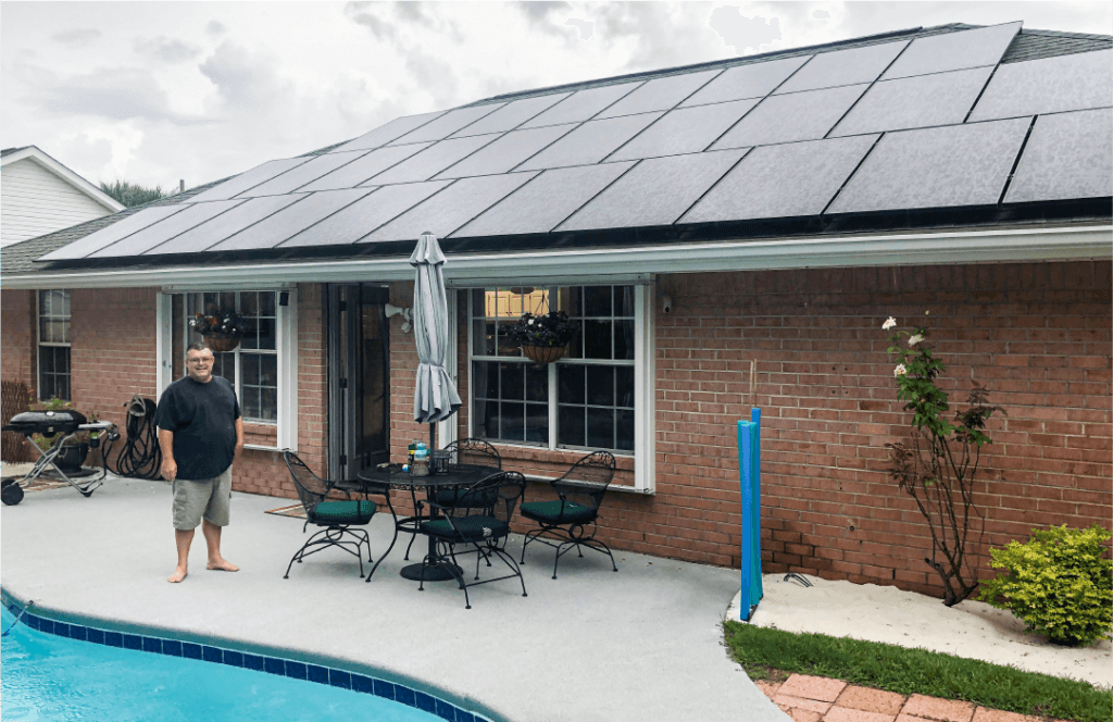 Keep your system running smoothly with solar evaluation reports from SunFarm Energy. A proud SunFarm Energy customer stands outside in front of his sytem.