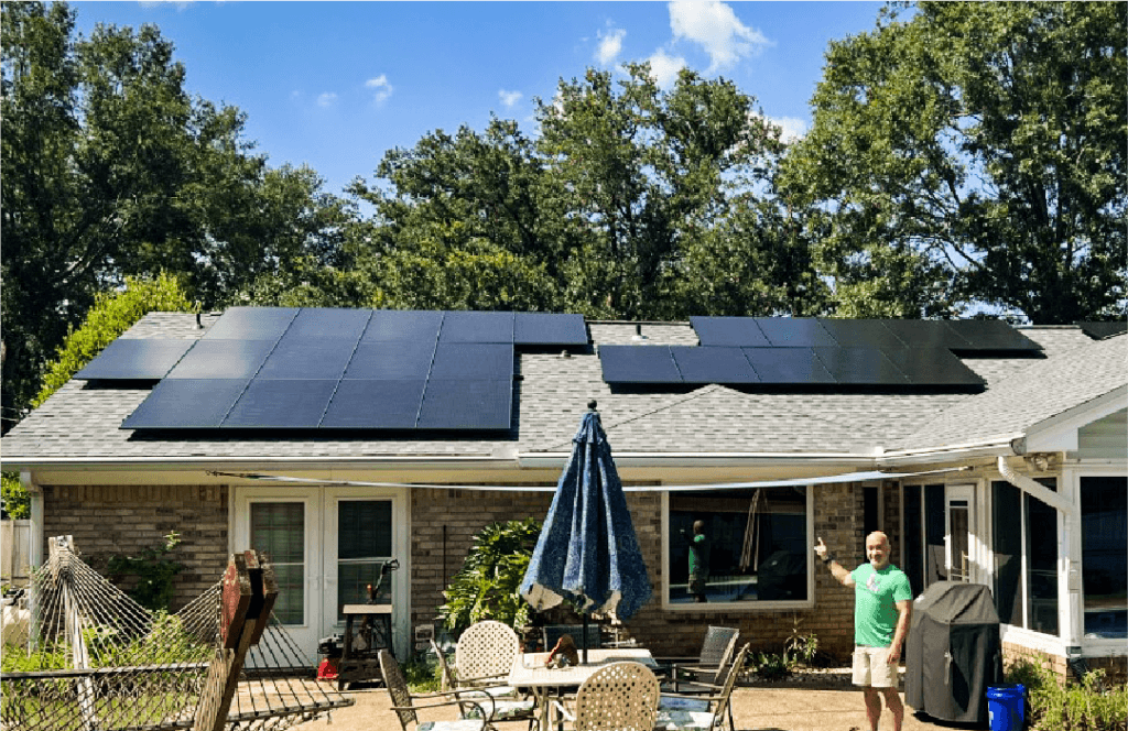 Keep your system running smoothly with solar evaluation reports from SunFarm Energy. A SunFarm customer stands outside pointing at his system.