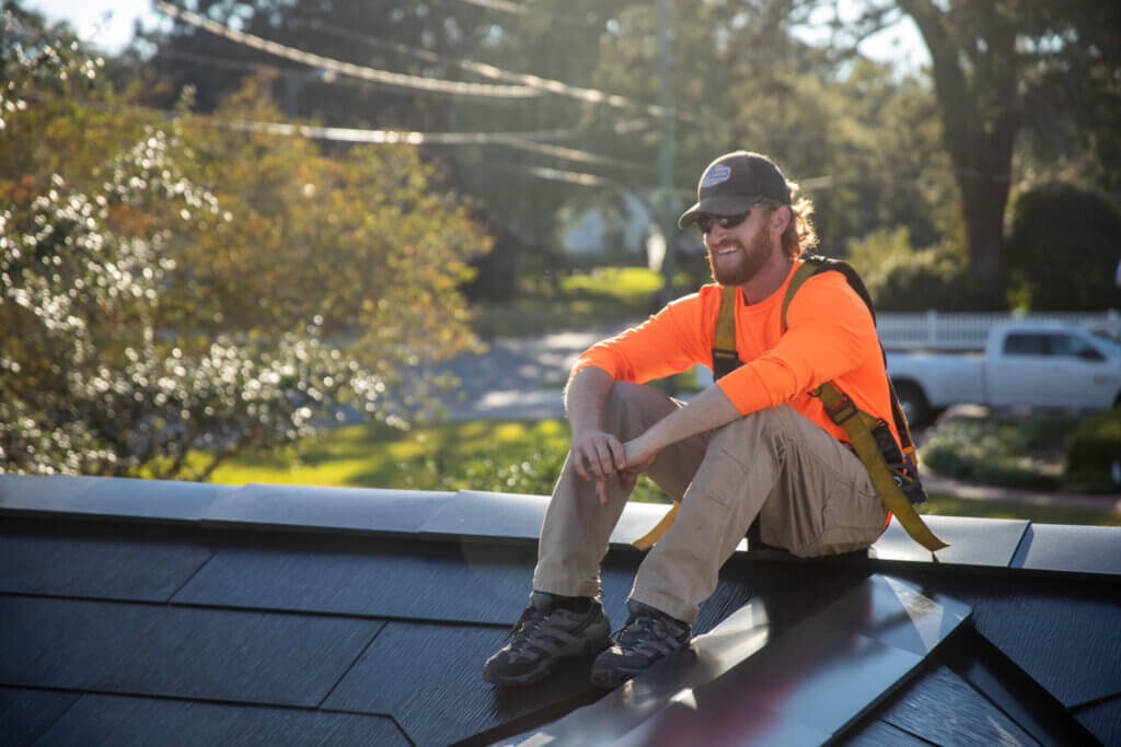 Jack Kelly sits on a roof during our solar + storage project shoot.