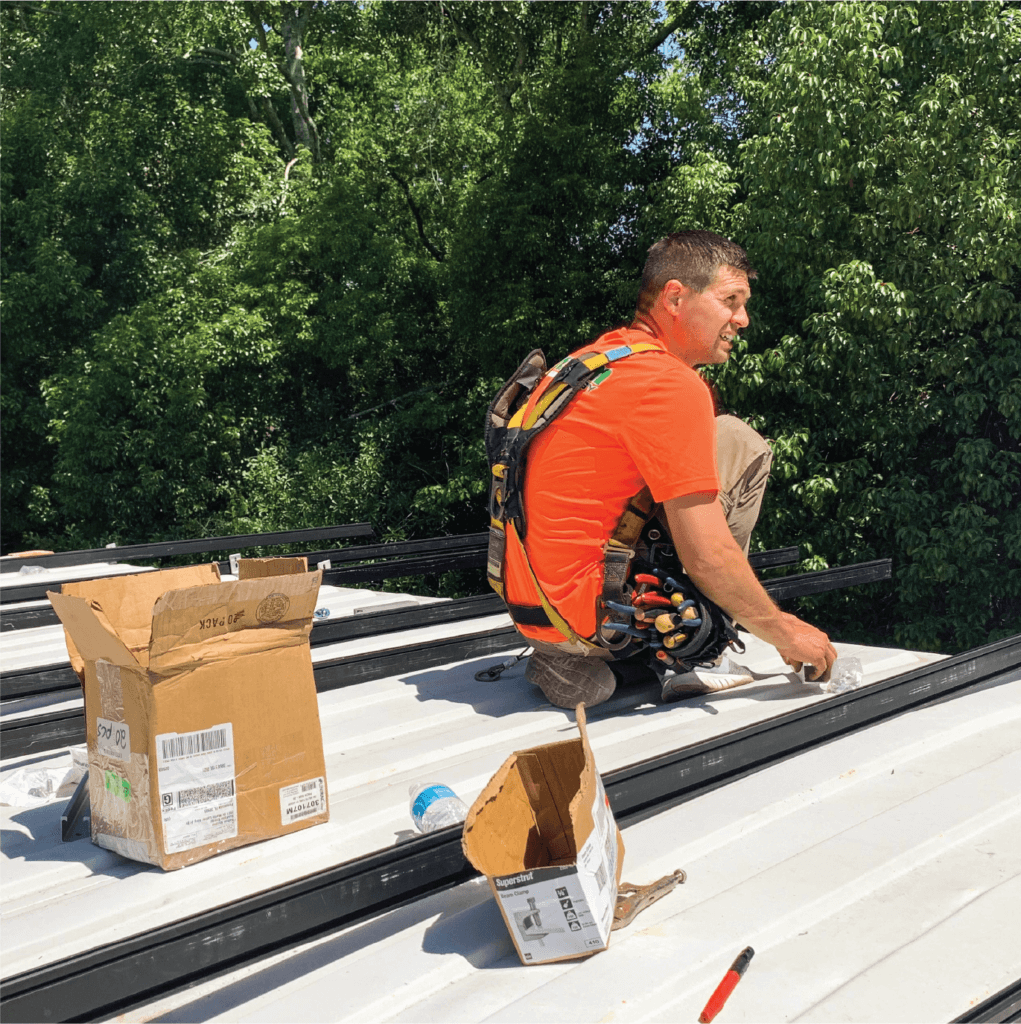 SunFarm Energy crew members install the racking system on top of the container classroom.
